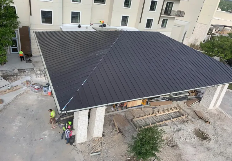 Metal roofing installation team working on a commercial building in Bradley